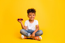 Full Length Photo Of Sweet Cheerful Small Boy Wear White T-shirt Rising Binoculars Isolated Yellow Color Background