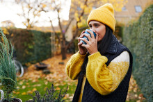 Young Woman Drinking Coffee While Gardening