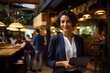 © kabir - Restaurant Owner Woman in Her Restaurant Holding a Tablet