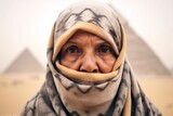 Close-up portrait photography of a content mature woman wearing a versatile buff in front of the pyramids of giza in cairo egypt. With generative AI technology