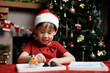 young girl wearing santa hat was making Christmas craft at home