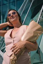 Fashion's Day Out: Model's Sunny Stroll In Pink Dress And Modern City Backdrop
