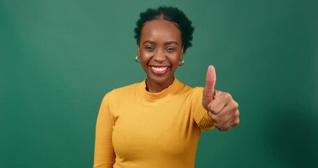 Wall Mural - Beautiful Black woman gives thumbs up, green studio background