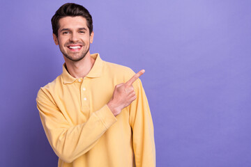 Sticker - Photo of positive good mood man dressed yellow shirt pointing finger empty space isolated purple color background