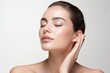 © gankevstock - beautiful woman with clear and fresh skin is touching her face against a white background, indicating facial treatment, cosmetology, beauty, and spa concepts