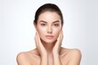 © gankevstock - beautiful woman with clear and fresh skin is touching her face against a white background, indicating facial treatment, cosmetology, beauty, and spa concepts