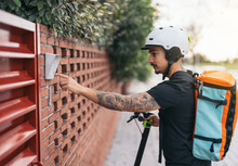 Courier Man Ringing Doorbell Of House In Neighborhood