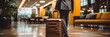 Close-up of a man walking with a suitcase in hotel. Hotel Concept with a Copy Space.