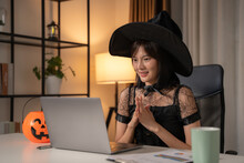 Female Influencer Wearing Witch Costume And Live Streaming At Home. She Talking To Her Fan Club With Smiling In Living Room At Home.