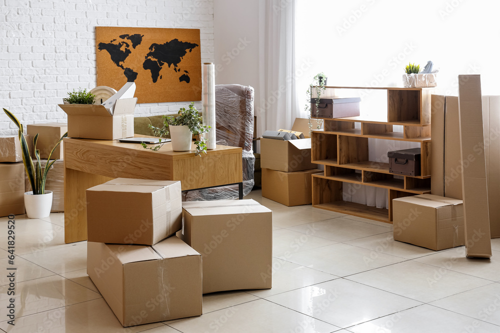 Modern workplace with cardboard boxes in office on moving day