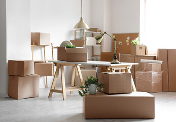 Wall Mural - Modern workplace with cardboard boxes in office on moving day