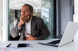 © Liubomir - Sick man at workplace inside office, african american man got food poisoning on lunch break, businessman has nausea and burps while sitting at desk.