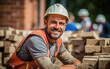 © ЮРИЙ ПОЗДНИКОВ - Happy bricklayer looking at the camera in the workplace.