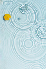 Wall Mural - Water background with ripples and drops and yellow autumn leaf