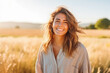Portrait of beautiful young caucasian woman smiling while standing in field of wheat, natural light