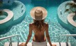Rear view of young woman in straw hat sitting by swimming pool. Vacation Concept with a Copy Space.