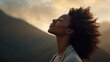 © Justlight - A strong African female with her eyes closed in concentration her body still against a muted out of focus mountain range in the background.