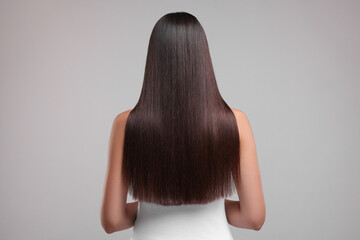 Wall Mural - Woman with healthy hair after treatment on light gray background, back view