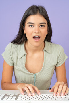 Surprised hispanic woman using computer with an amazed look