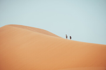 Wall Mural - People climbing Erg Chebbi dunes in Sahara Desert, Merzouga, Morocco