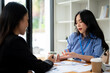 A professional and focused Asian businesswoman or auditor is discussing plan with a client