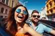 © ttonaorh - Happy young couple driving a convertible car on a city street. Summer vacation and travel concept