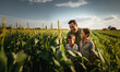 A farmer and his two sons examine the future corn harvest. a tractor in the background. Generative ai