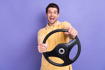 Wall Mural - Portrait of overjoyed nice person have good mood hands hold steering wheel isolated on purple color background