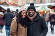 Happy young smiling black couple in winter clothes at street Christmas market in Stockholm