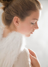 Close Up Of Young Woman With White Feather Wings
