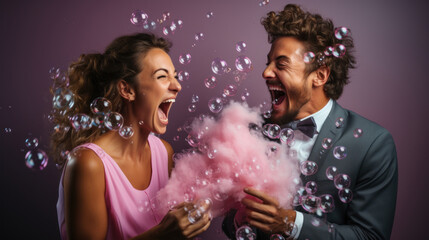 Portrait of a happy crazy couple blowing soap bubbles on purple background.