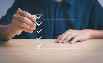 Poster - Businessman holding pen mark in check box, concept of checklist, approval document, quality control(QC) ,questionnaires ,online surveys or digital document management systems