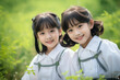 © Keitma - Two young asian schoolgirls in casual school uniform in a green park