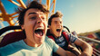 © Keitma - Two friends guys riding a rollercoaster at an amusement park experiencing excitement, joy, laughter, and fun