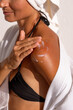 with the procedure of applying moisturizer to a woman's shoulder