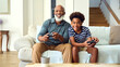 © Monkey Business - Grandfather And Grandson On Sofa At Home Playing Video Game Together With Boy Celebrating Win