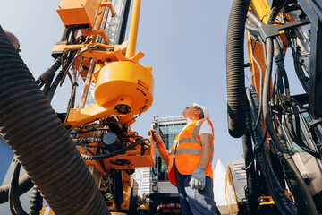 Hydraulic engineer doing safety check on new installation hoses of modern drilling industrial machine. Concept industry work