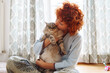 © larisikstefania - Portrait red-haired curly young woman with beloved fluffy domestic cat