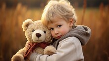 A Cute Little Baby Boy Hugging His Big Soft Stuffed Teddy Bear Toy While Walking And Standing Outside On The Nature At A Wheat Field. Generative AI