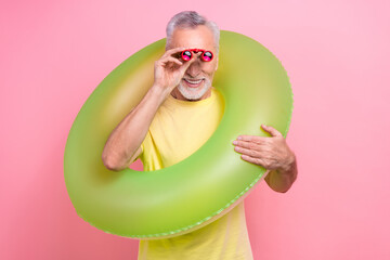 Sticker - Photo of professional lifeguard senior grey hair man watching how people chill swimming pool binoculars isolated on pink color background