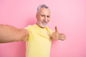 Wall Mural - Portrait of satisfied nice retired person wear stylish t-shirt showing thumb up approve doing selfie isolated on pink color background