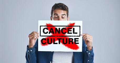 Wall Mural - Cancel culture, person and protest sign in hand with message for social media violence and support in studio. Banner, man and face with mockup space for solidarity and opinion on grey background