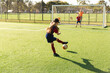 © Austockphoto - girl playing soccer and kicking a goal