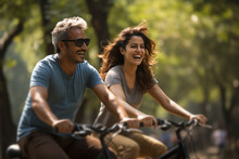 Happy Indian Couple Riding On Bicycle In The Park