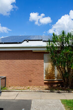 Plain Brick Wall And Corrugated Roof With Solar Panels