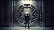 The Banker Stands In Front Of The Iron Door Of The Vault. Bank Vault Room. High Level Locking Mechanism.