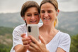Cheerful mother and son taking selfie on smartphone
