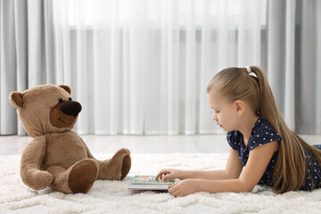 Sticker - Cute little girl playing with teddy bear at home