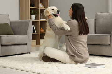 Wall Mural - Woman with cute Labrador Retriever dog on floor at home. Adorable pet