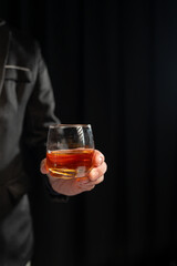 Close up shot of asian businessman holding glass of whiskey, alcohol, wine in hand with depression and sadness in face of financial or family problems.